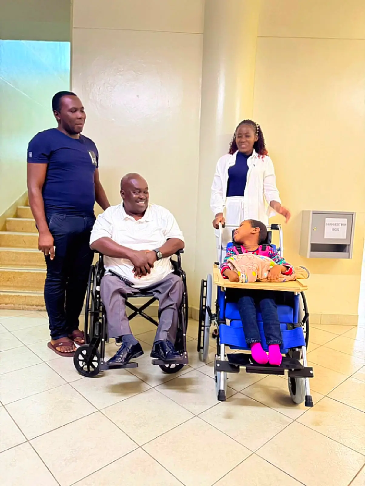 A man and a child receiving wheelchairs at a support centre
